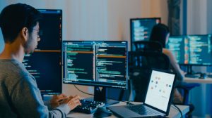 Group Adult Asia male, female freelance typing write prompt AI bot IT app smart program nomad, video game, terminal with coding language, designer, big data center on computer in night office.